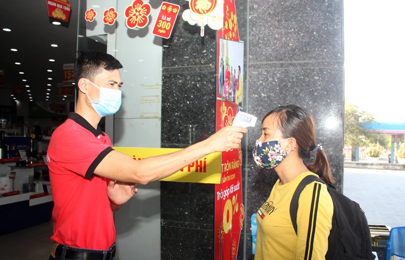 Khách hàng đến mua sắm tại siêu thị được kiểm tra thân nhiệt.