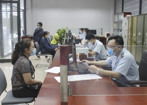 Cán bộ hải quan và nhân viên doanh nghiệp đeo khẩu trang khi giao dịch.
