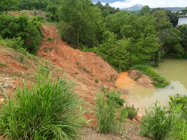 Sau mỗi trận mưa, nước trên đường, đồi chảy xuống đọng tại tổ 9, 10, phường Bình Minh. Ông Thảo chủ động làm rãnh để bùn đất, nước bẩn không trôi vào nhà.