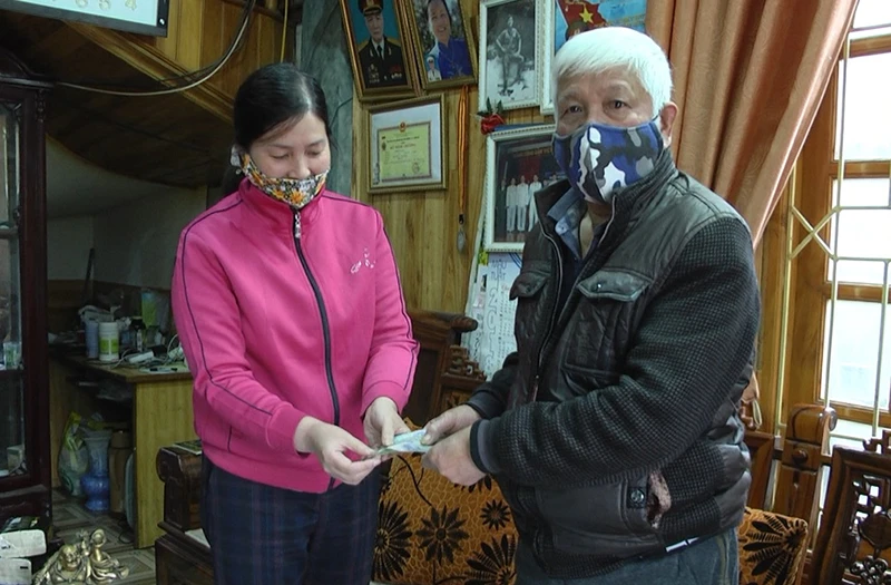 Đại diện Ủy ban MTTQ Việt Nam thị xã Sa Pa phát tiền hỗ trợ cho người dân.