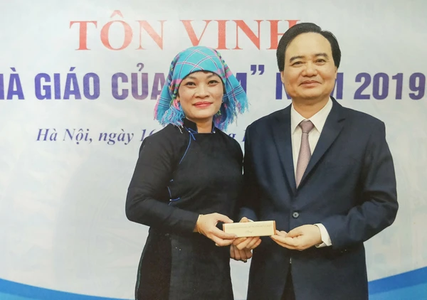 Cô Hạnh được Bộ trưởng Phùng Xuân Nhạ tặng quà kỷ niệm trong Lễ vinh danh nhà giáo tiêu biểu của năm 2019.