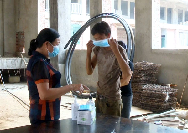 Phát khẩu trang và hướng dẫn công nhân sát khuẩn tay trước và sau khi làm việc.