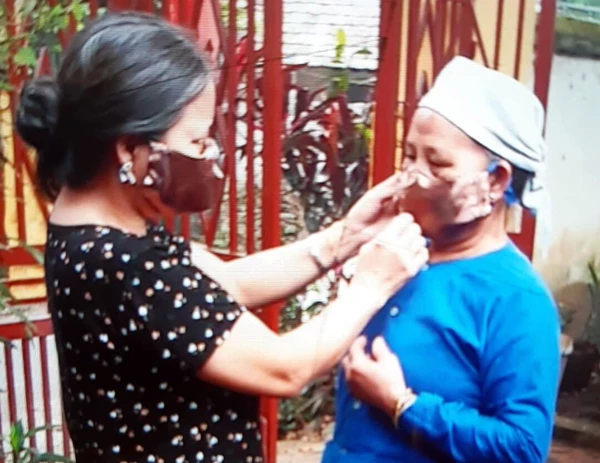 Chị Hường tặng khẩu trang cho phụ nữ địa phương.
