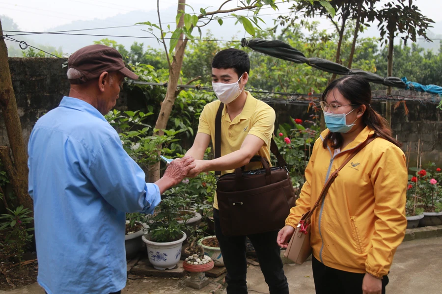 Phát khẩu trang miễn phí cho người dân trước khi tiến hành chi trả.