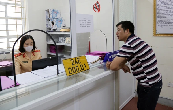 Người dân được cán bộ Phòng Cảnh sát giao thông Công an tỉnh hướng dẫn làm thủ tục đổi biển số cho phương tiện tham gia kinh doanh vận tải.