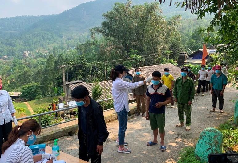 Người dân được đo thân nhiệt trước khi nhận gạo.