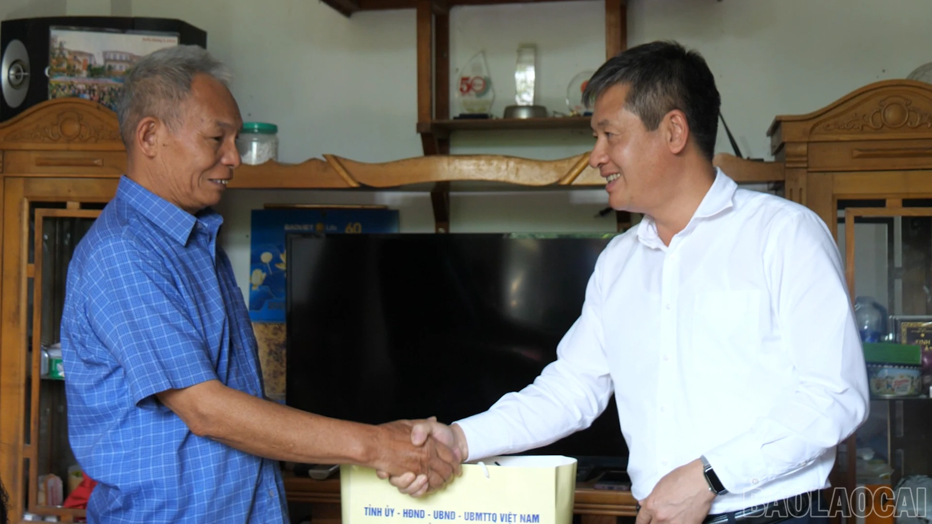 Đồng chí Phó Chủ tịch Thường trực UBND tỉnh Ngô Hạnh Phúc tặng quà ông Lục Tiến Tình.