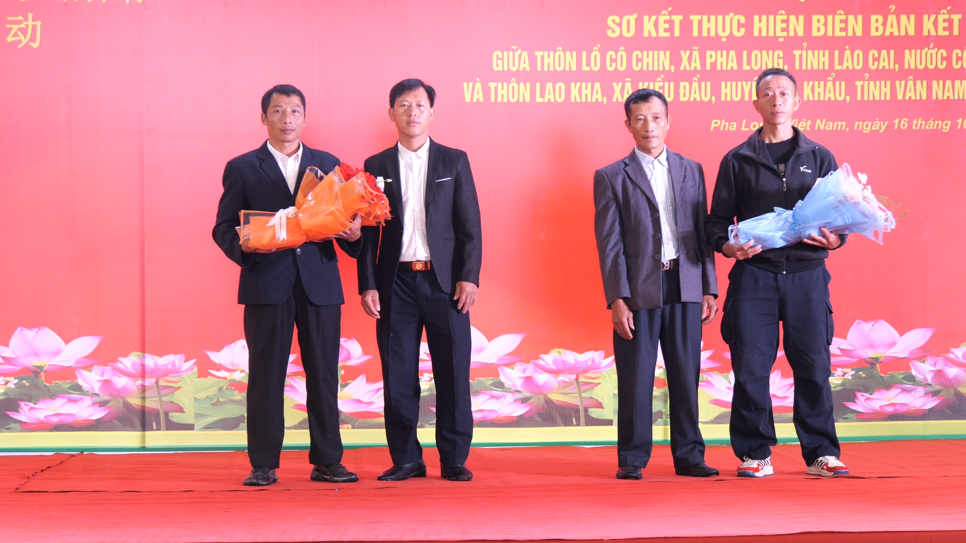 Lãnh đạo 2 thôn Lồ Cố Chin (Việt Nam) và Lao Kha (Trung Quốc) tặng hoa tại hội nghị sơ kết. so-ket00-04-18-07still004.png