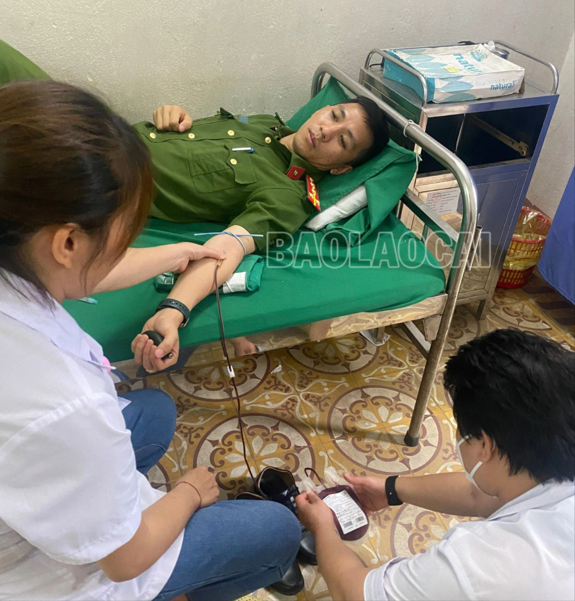 Đồng chí Đại úy Định Công Chiến đang được các bác sỹ lấy máu để kịp thời cứu sống bệnh nhân.jpg