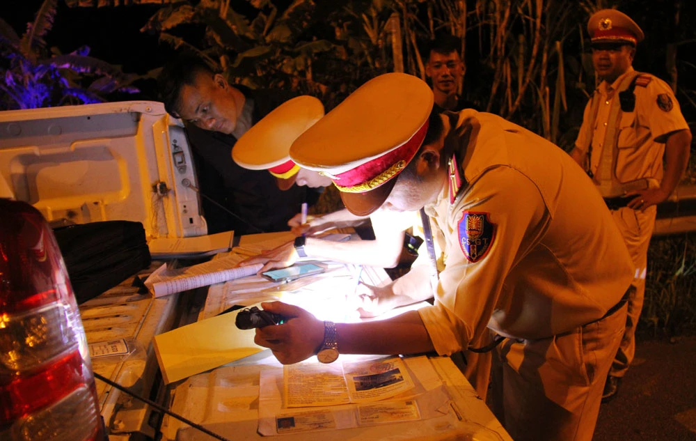 Lực lượng CSGT tiến hành lập biên đối với trường hợp chở quá tải trọng quy định.JPG