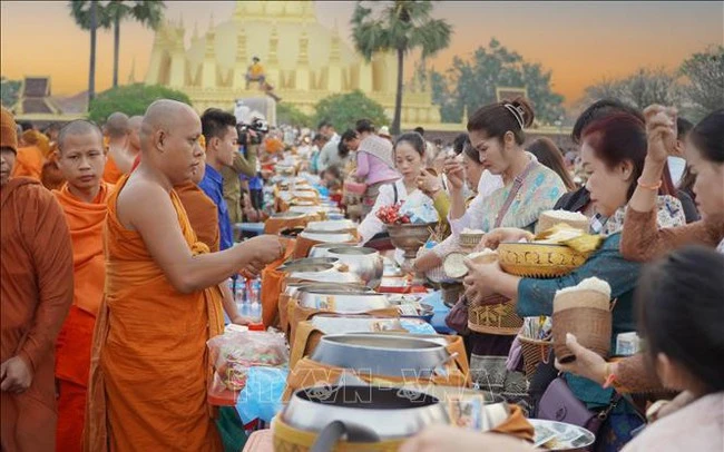 Người dân xếp hàng trang nghiêm và thực hiện nghi lễ Xaybat (cúng dường).