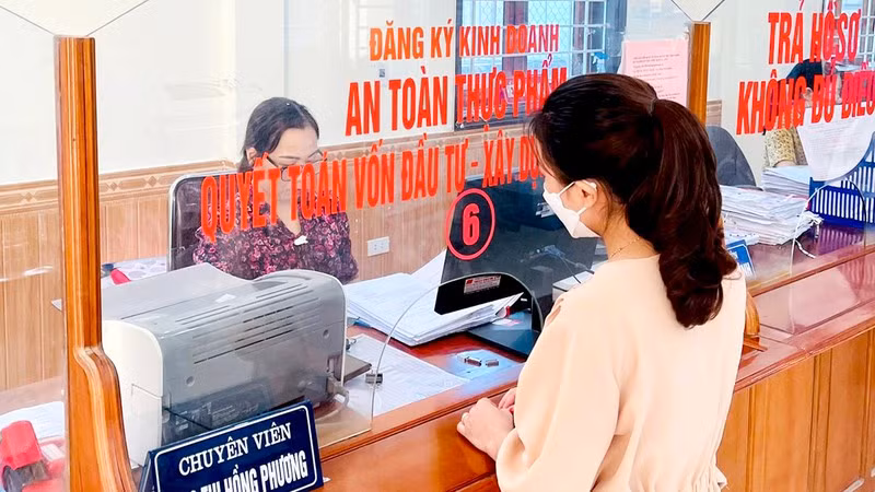 Công chức Bộ phận một cửa huyện Nghi Lộc (Nghệ An) giải quyết thủ tục hành chính cho người dân.