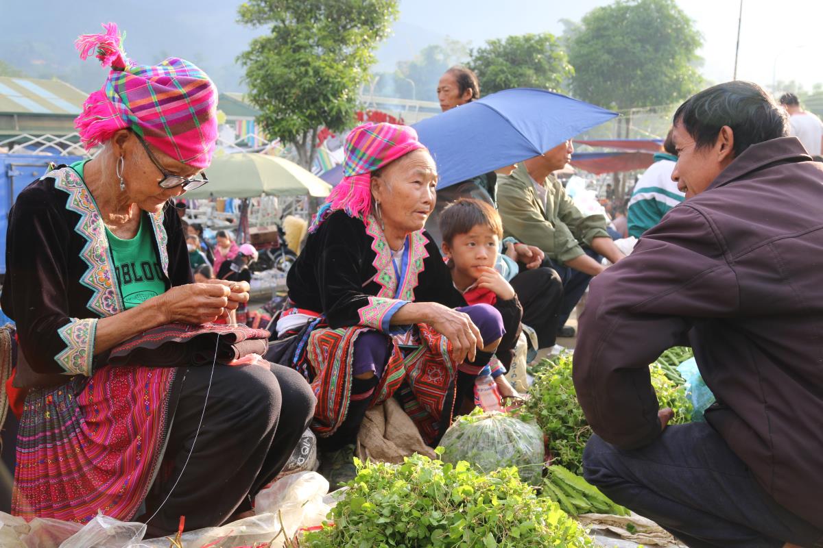 Người dân tranh thủ khâu thêu thổ cẩm trong lúc vắng khách - nét đẹp văn hóa thường thấy ở các phiên chợ. Người dân tranh thủ khâu thêu thổ cẩm trong lúc vắng khách - nét đẹp văn hóa thường thấy ở các phiên chợ.