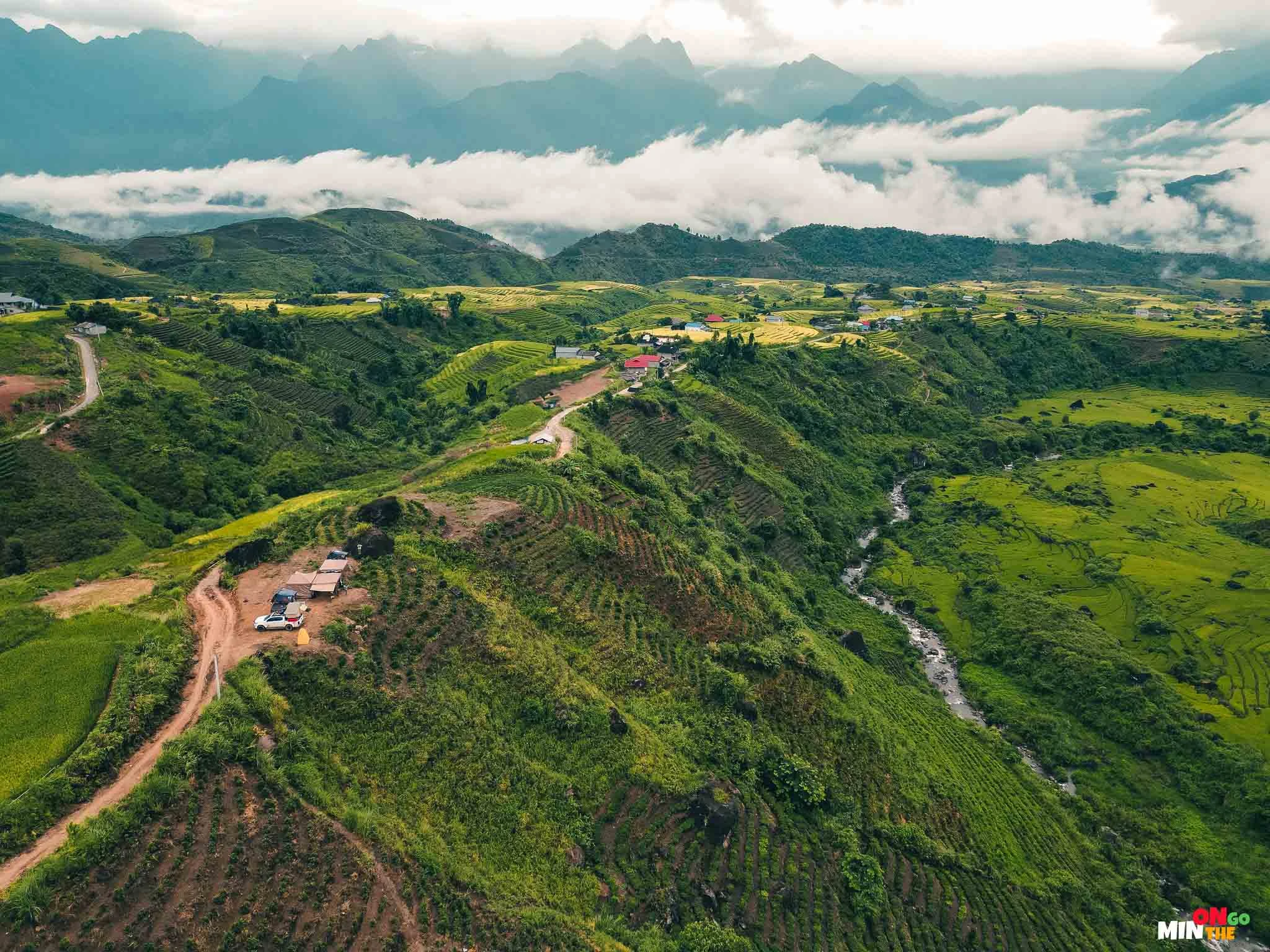 Bên dưới điểm cắm trại là dòng suối trong vắt, phía xa là những thửa ruộng bậc thang, đồi chè và dãy núi hùng vĩ.
