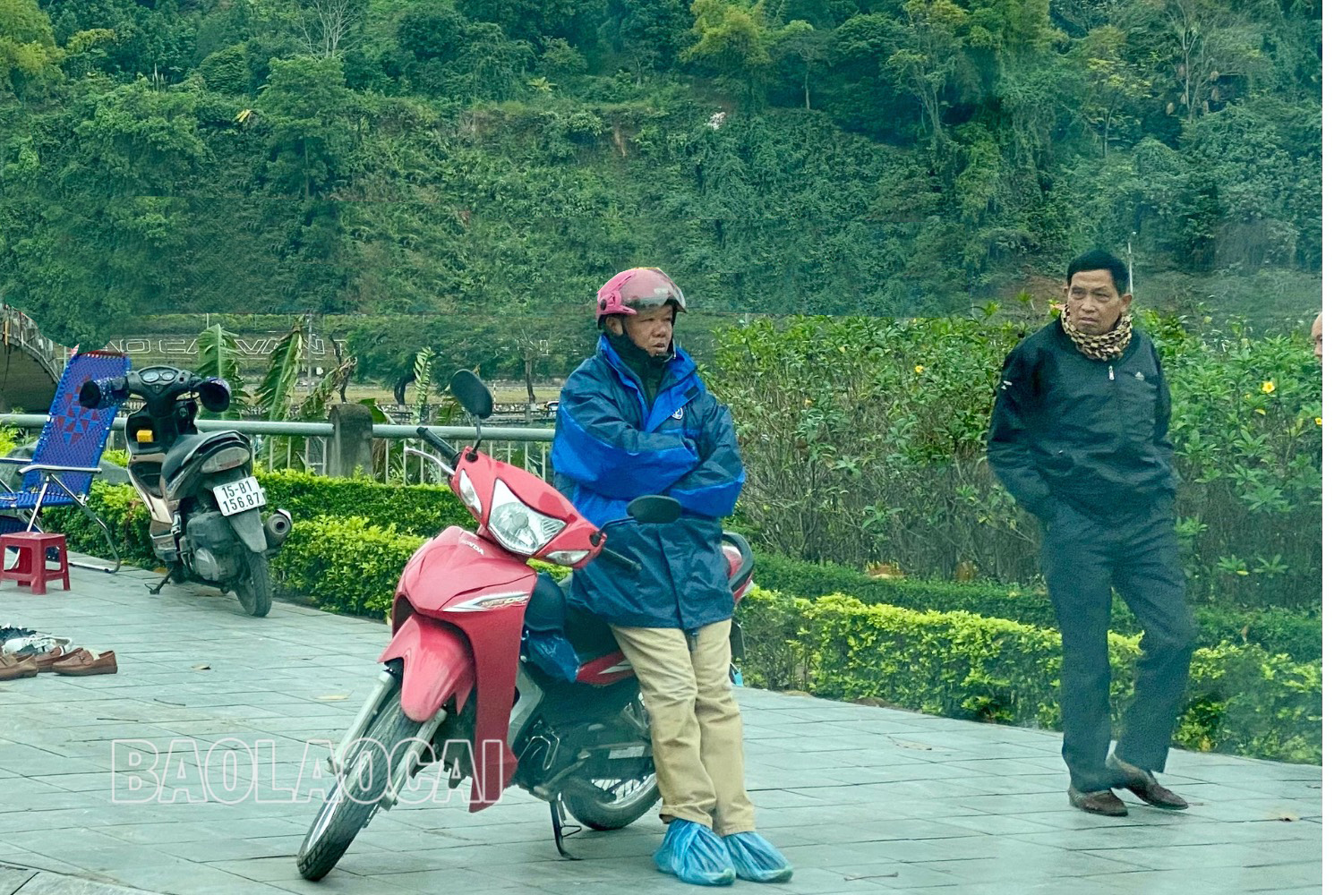 Một tài xế xe ôm tại chợ Cốc Lếu mặc áo ấm cùng áo mưa để chống lại cái lạnh. thiet-ke-chua-co-ten1.jpg