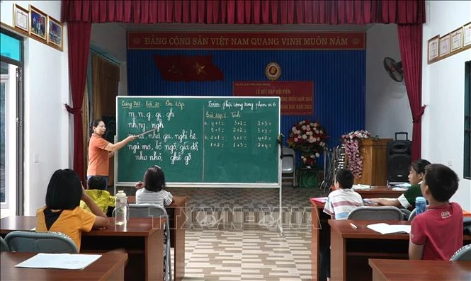 Cô giáo Hoàng Thị Vỵ (người dân tộc Cao Lan ở thôn Ngòi Khang, xã Bảo Ái, huyện Yên Bình, tỉnh Yên Bái) dạy chữ và hỗ trợ chăm sóc trẻ bị khuyết tật.