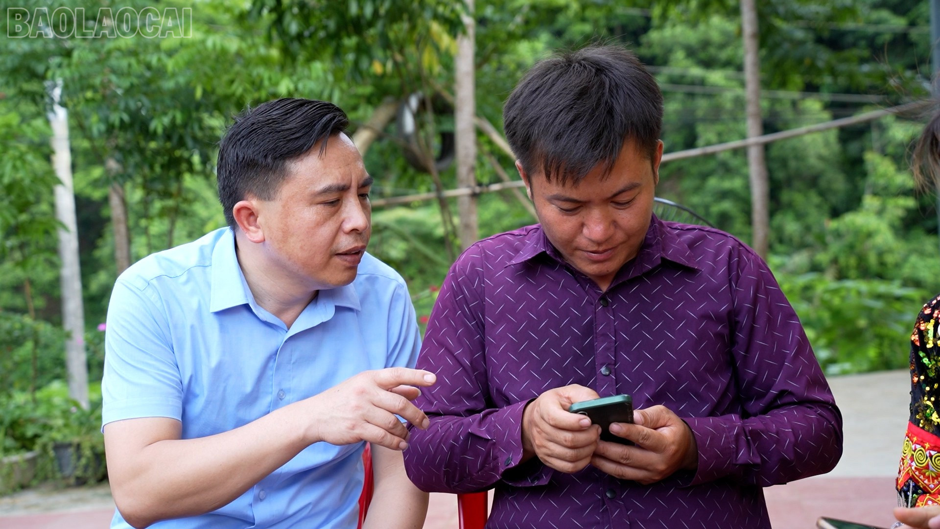Ông Nguyễn Ngọc Thắng - Chủ tịch Ủy ban Mặt trận Tổ quốc Việt Nam xã Bảo Hà hướng dẫn người dân thôn 2 Nhai Tẻn đăng nhập VNeID trên điện thoại. baolaocai-tl_5.jpg