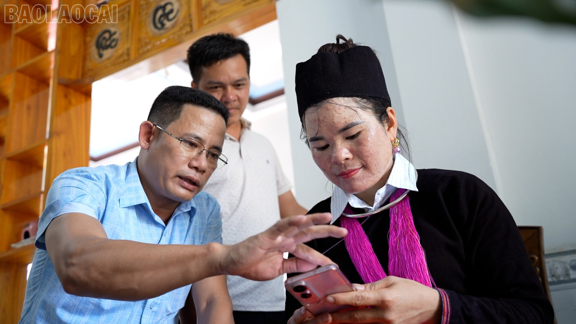 Ông Nguyễn Văn Thắng -Phó Giám đốc Trung tâm Phục vụ hành chính công xã Bảo Hà hướng dẫn bà con thôn 1 Nhai Tẻn truy cập dịch vụ công trực tuyến trên điện thoại. baolaocai-tl_7.jpg