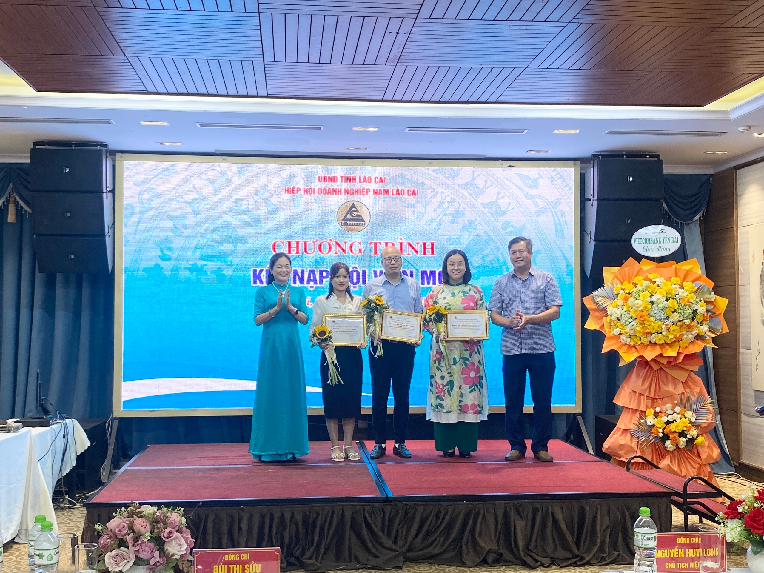 Đại diện lãnh đạo Hiệp hội Doanh nghiệp Nam Lào Cai trao quyết định kết nạp và tặng hoa cho 3 doanh nghiệp hội viên mới. 3dn.jpg