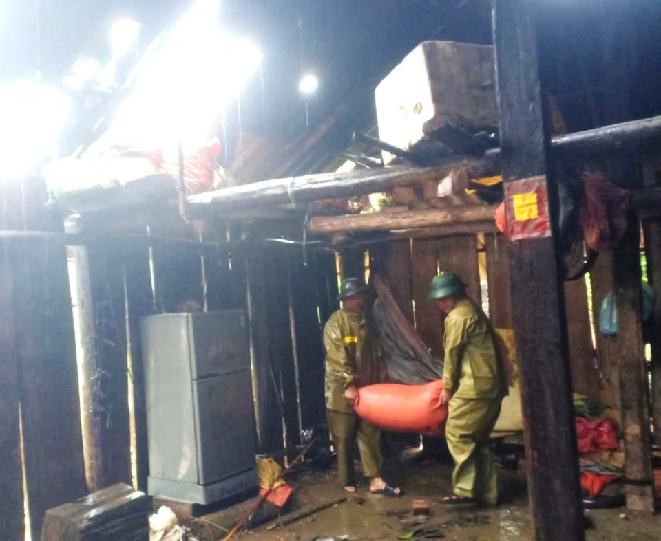 Lực lượng chức năng hỗ trợ di dời nhà dân bị tốc mái.