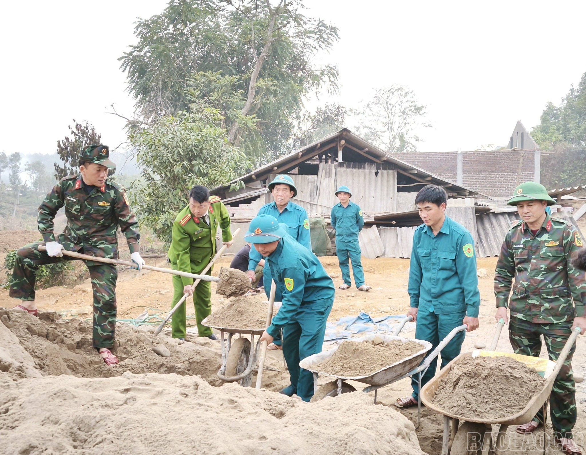 Các lực lượng công an, quân đội hỗ trợ người dân làm nhà.