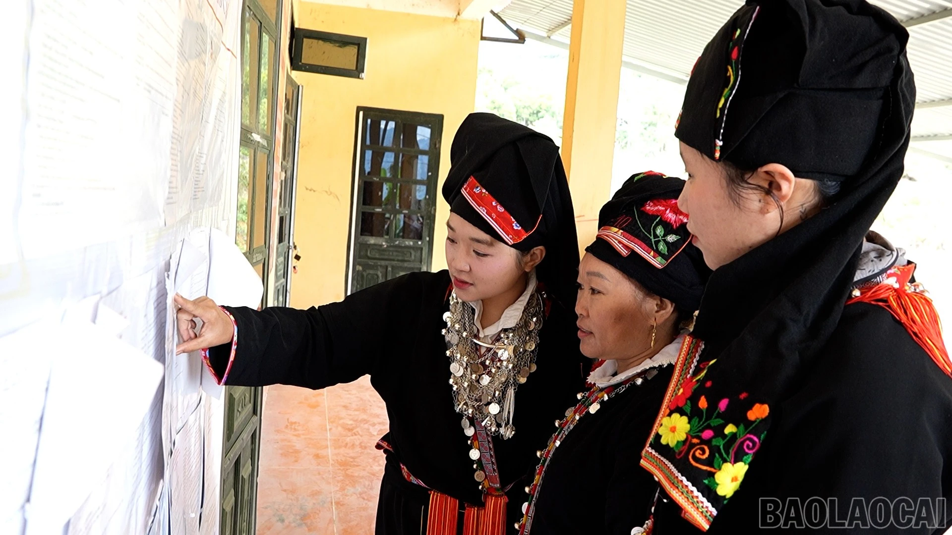 Người dân xã Sơn Lương tìm hiểu tiểu sử của các ứng cử viên.