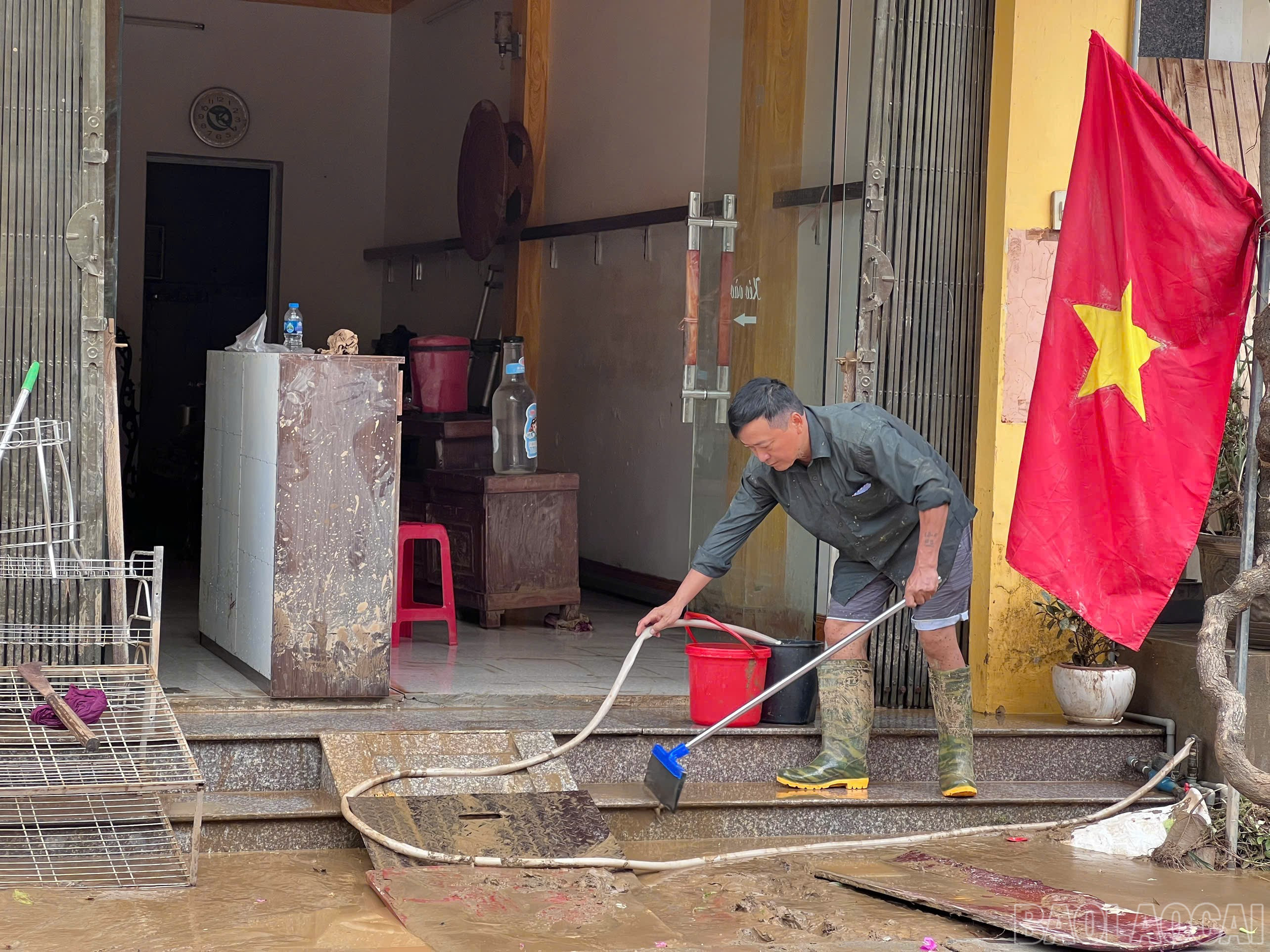 Ông Miền khẩn trương dọn dẹp bùn đất để sớm ổn định cuộc sống. baolaocai-br_z7069453331093-fbf78287d6500eb25020c9fdcfb2f648.jpg