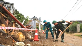 Cán bộ, chiến sĩ Bộ CHQS tỉnh hỗ trợ các hộ dân khắc phục hậu quả sạt lở đất tại xã Xuân Ái