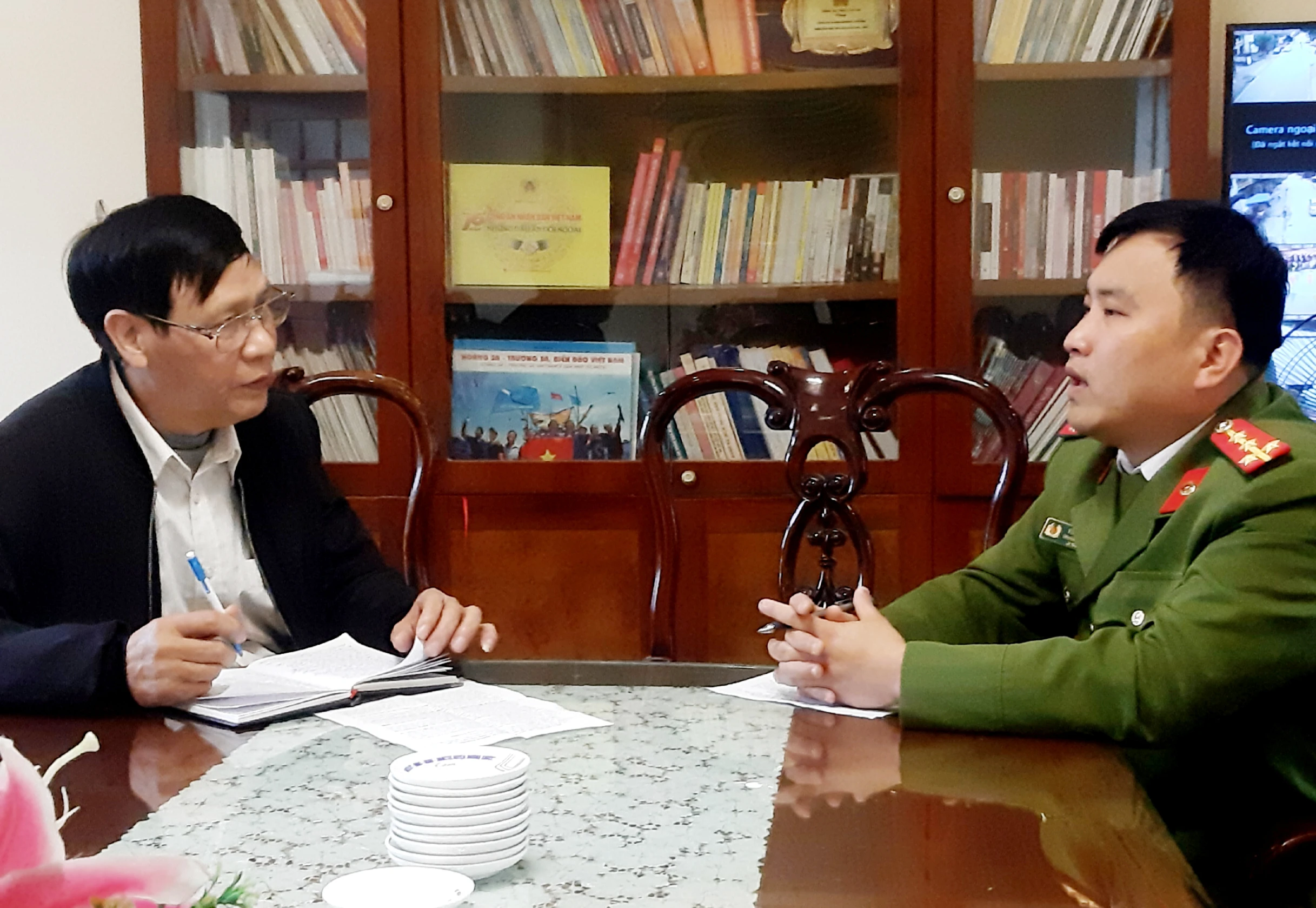 Đại úy Vũ Xuân Quân, Trưởng Công an xã Bản Lầu làm việc với tác giả Công Thế..jpg