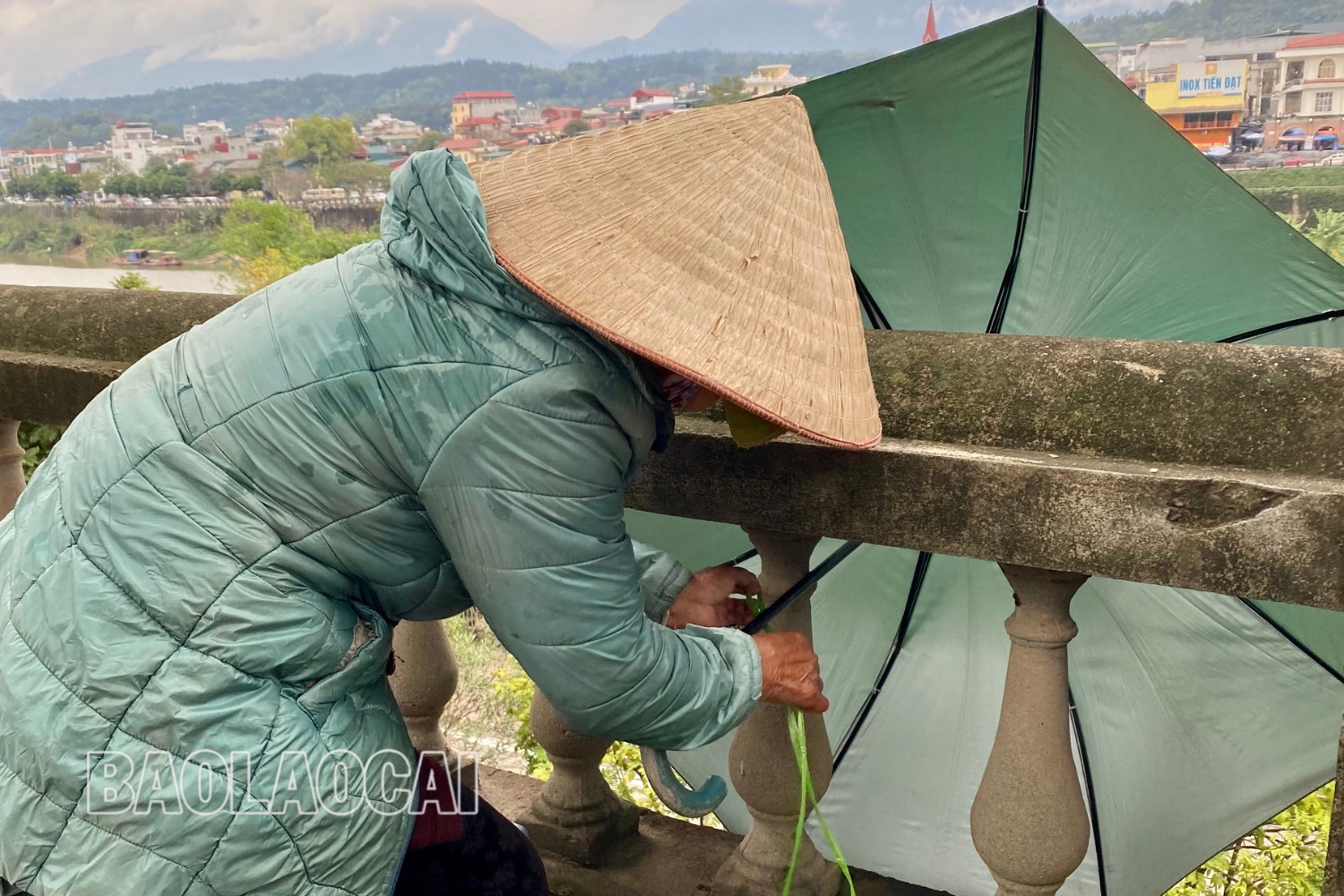 Bà Tâm năm nay đã ngoài 80 tuổi, những ngày này, tuy thời tiết giá rét nhưng quán nước nhỏ của bà tại khu vực bờ kè vẫn đều đặn mở bán mỗi ngày. Khi nhiệt độ xuống thấp, bà Tâm dùng chiếc ô để chắn bớt gió lạnh lùa vào. Thiết kế chưa có tên - 3 (2).jpg