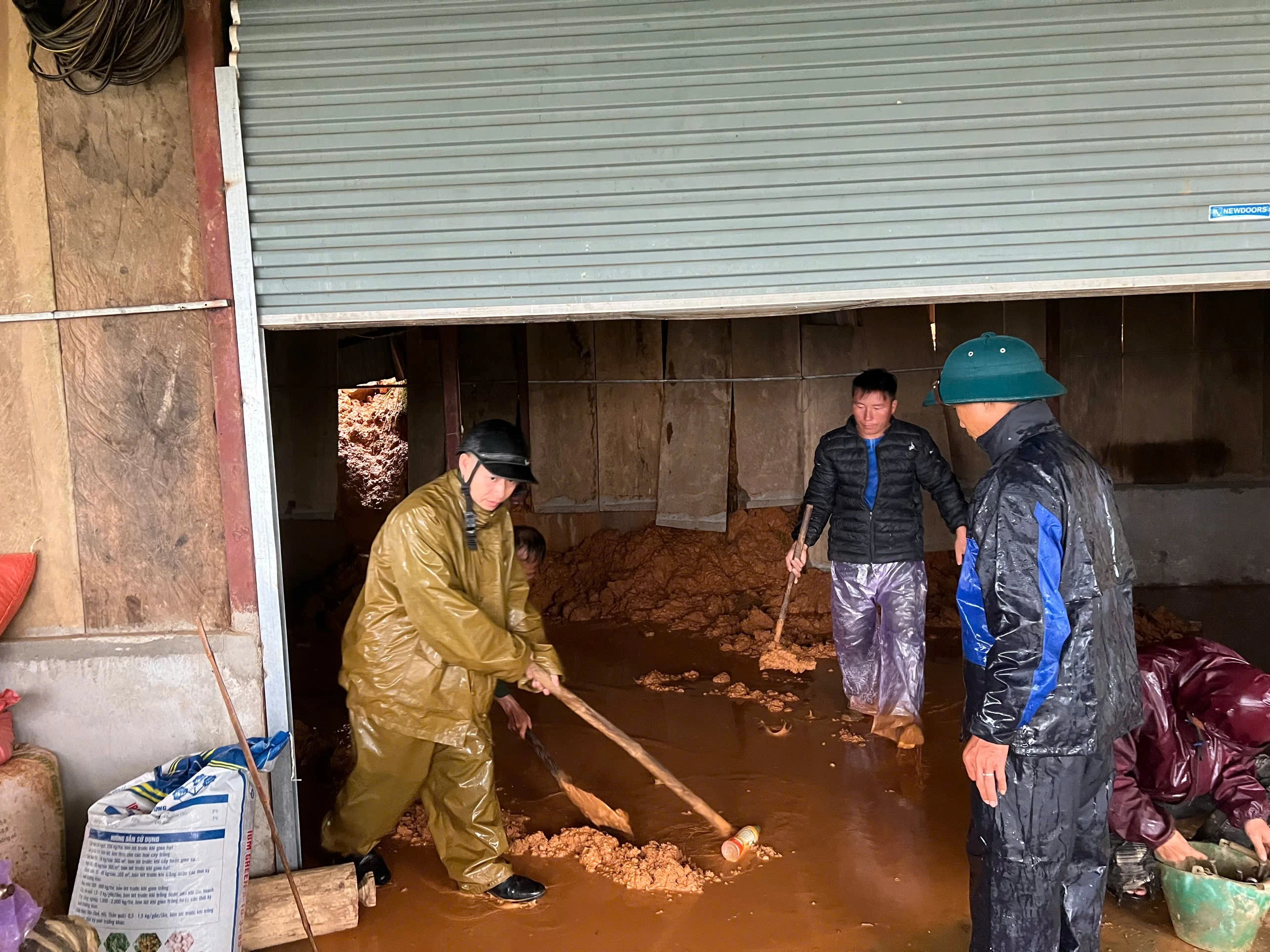 Lực lượng công an xã Trạm Tấu giúp các hộ dân bị đất, đá tràn vào nhà.