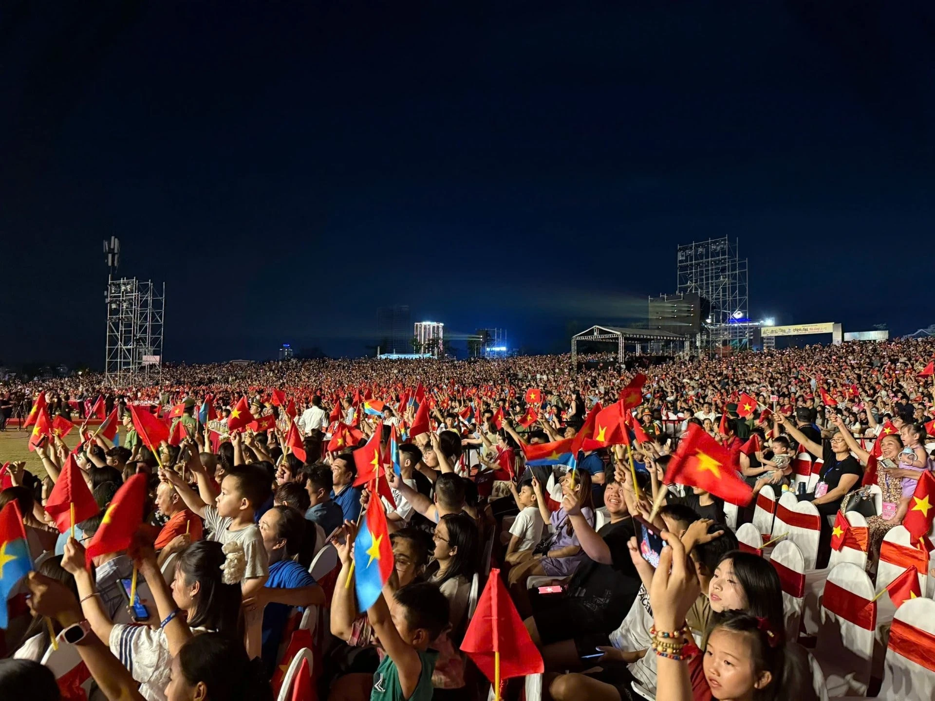 Đông du khách tham dự Caraval Hạ Long 2025 cầm cờ đỏ sao vàng lan toả tinh thần dân tộc.