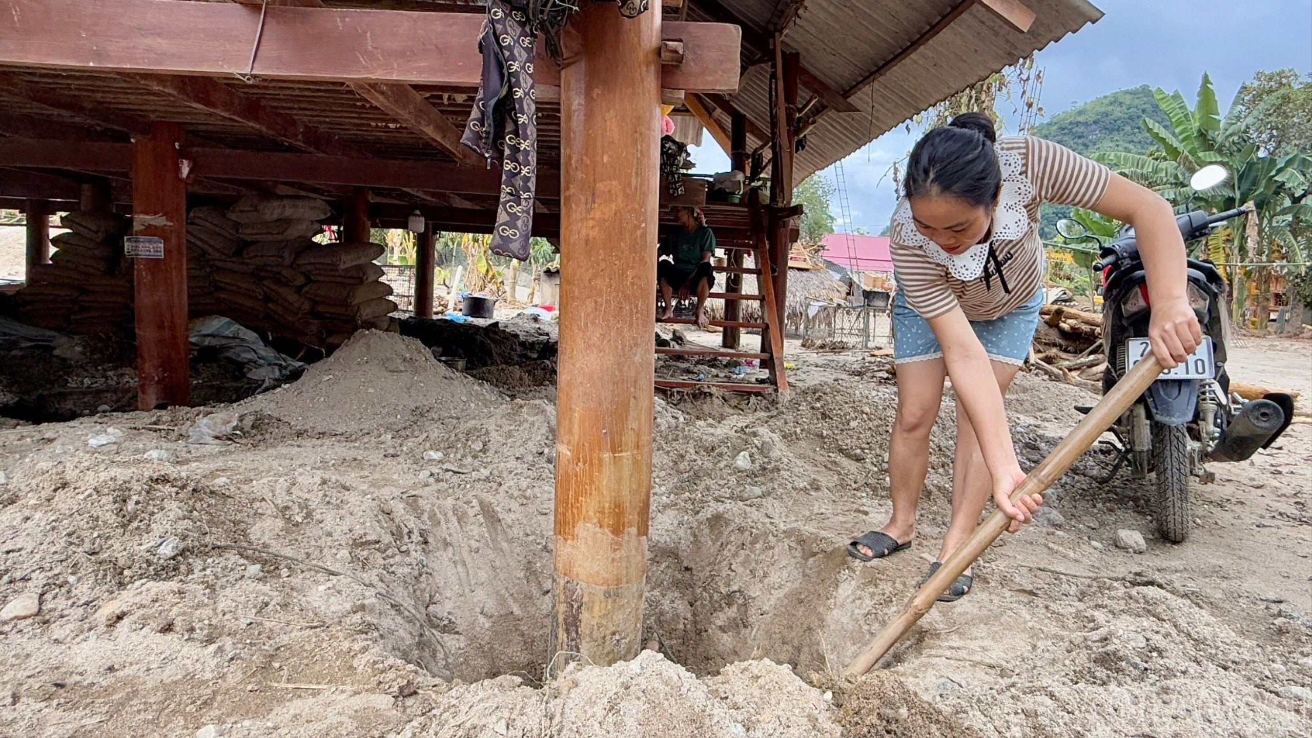 Để giữ nếp nhà sàn không bị ảnh hưởng, bà con giúp nhau đào hố dưới chân cột, khơi dòng để nước không bị ứ làm hỏng cột. baolaocai-br_br-z7162976471328-35dda12a2168d72d210d522c1c6d4483.jpg