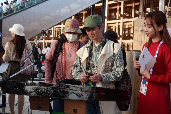 Du khách tại EXPO khám phá nhạc cụ truyền thống Việt Nam sau buổi biểu diễn.