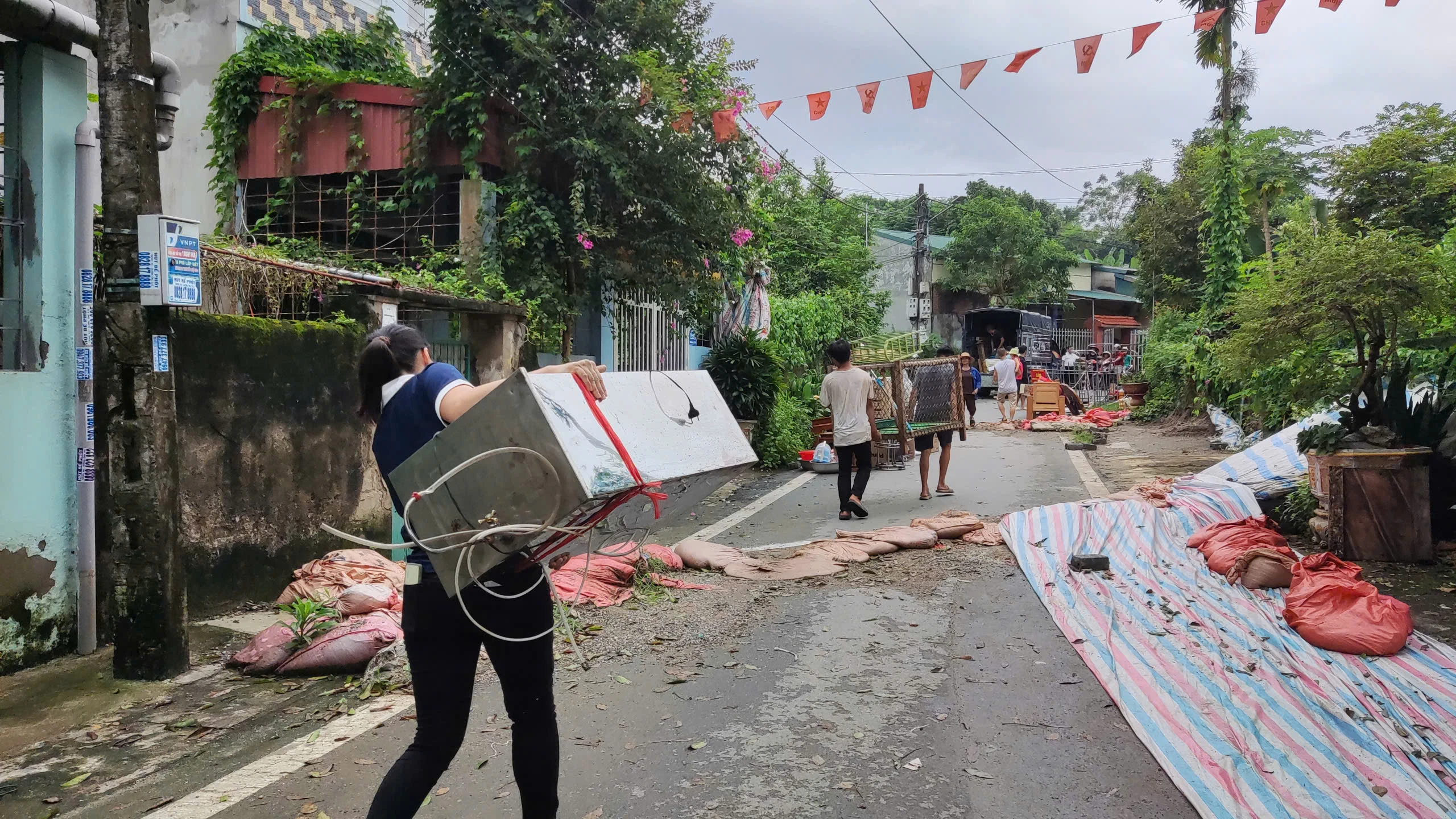 Người dân giúp nhau di chuyển đồ đạc.