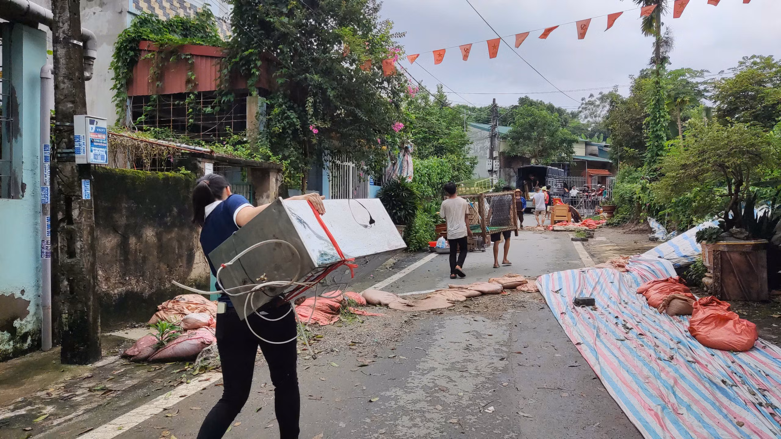 Người dân giúp nhau di chuyển đồ đạc.