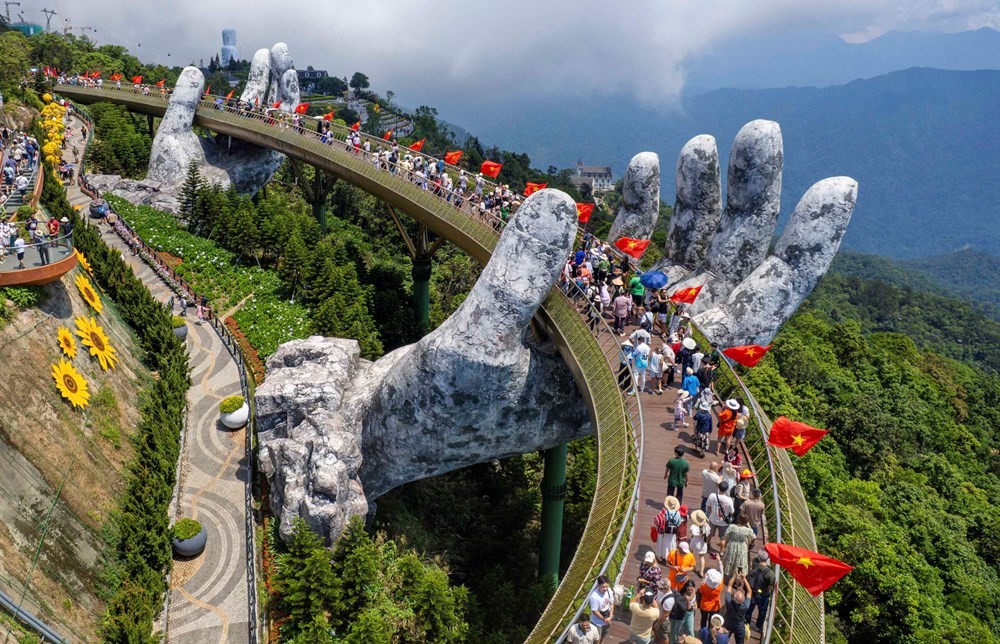 Die Goldene Brücke auf den Ba Na Hills lockt Touristen zum Einchecken an. Cầu Vàng trên đỉnh Bà Nà Hills thu hút du khách check-in.
