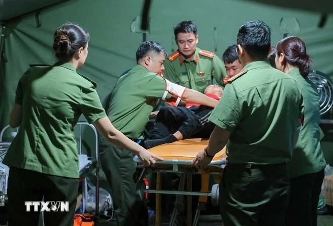 Các bác sỹ của Công an Hà Nội khẩn trương sơ cứu cho người dân bị ngã, có hiện tượng co giật khi đi xem lễ diễu binh, diễu hành tại trạm y tế dã chiến phố Liễu Giai.