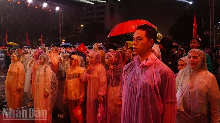 Khán giả hát Quốc ca trong mưa.