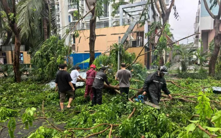 Dọn dẹp cành cây gãy, lá rụng, nước đọng, bùn đất và rác thải vương vãi sau khi cơn bão Kajiki đi qua ở Tam Á, tỉnh Hải Nam, Trung Quốc. 26-8baotq.jpg