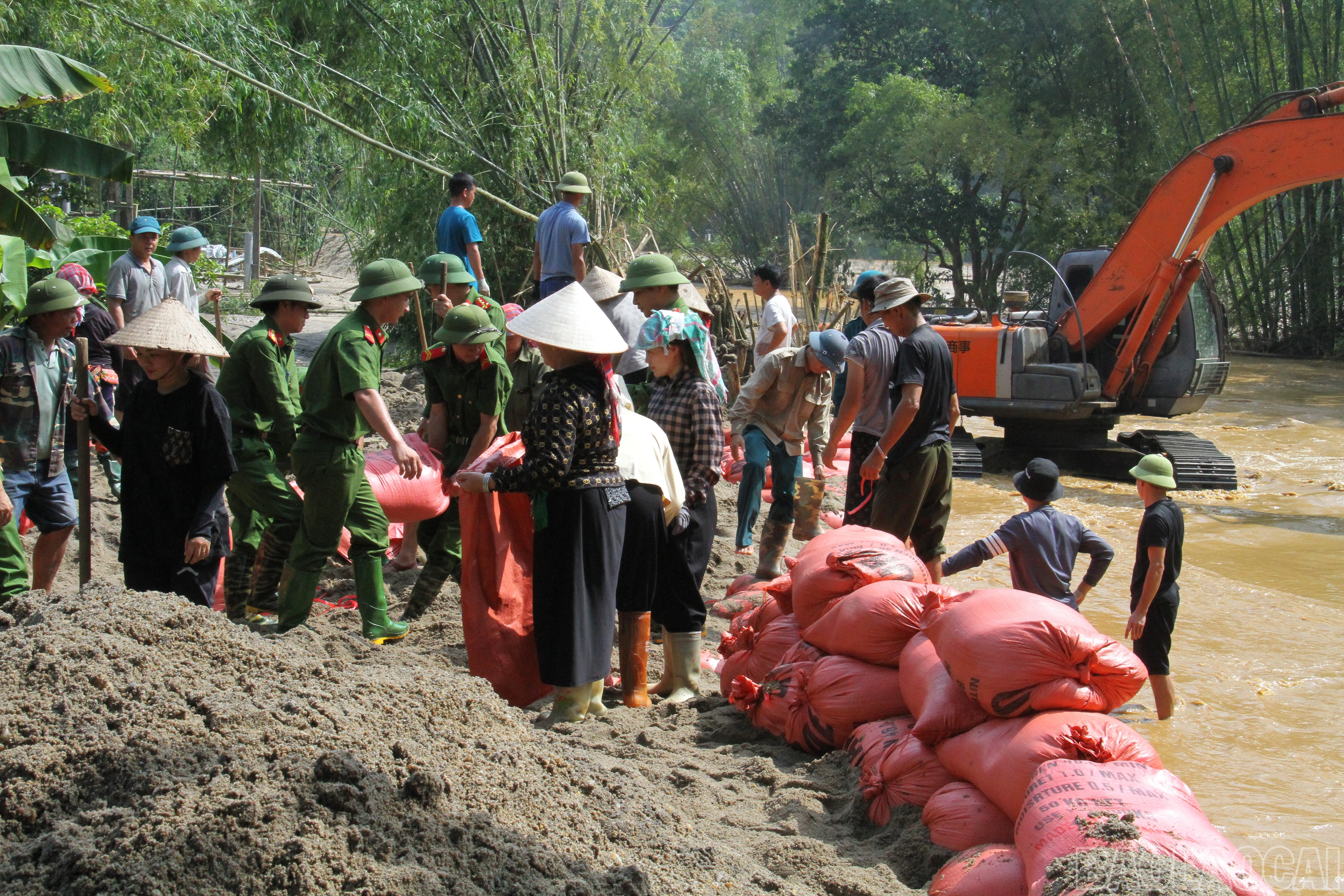 Công an xã cùng bà con nhân dân dùng bao cát làm đê chống lũ. baolaocai-br_vanban-4.jpg