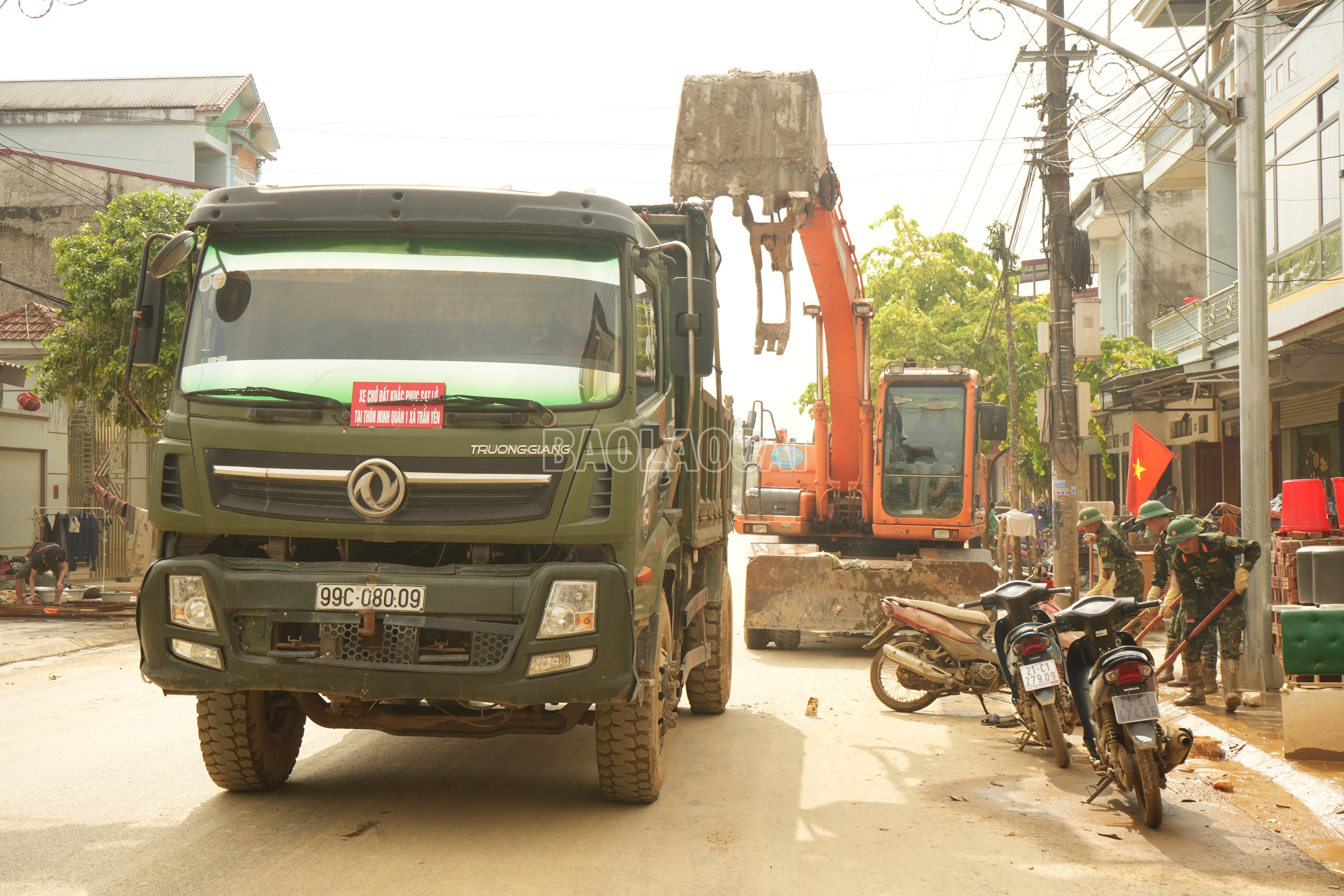 Máy xúc và xe cơ giới được huy động dọn đường và vận chuyển bùn đất, rác thải. baolaocai-c_mayxuc-2.jpg