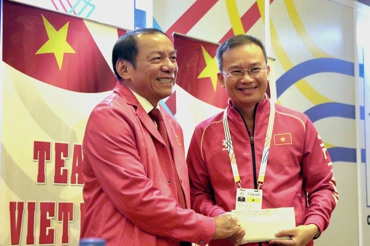 Bộ trưởng Bộ Văn hóa, Thể thao và Du lịch Nguyễn Văn Hùng (trái) trao thưởng "nóng" của bộ cho Trưởng đoàn thể thao Việt Nam Nguyễn Hồng Minh.
