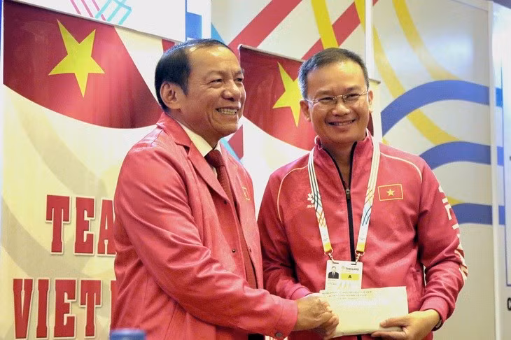 Bộ trưởng Bộ Văn hóa, Thể thao và Du lịch Nguyễn Văn Hùng (trái) trao thưởng "nóng" của bộ cho Trưởng đoàn thể thao Việt Nam Nguyễn Hồng Minh.