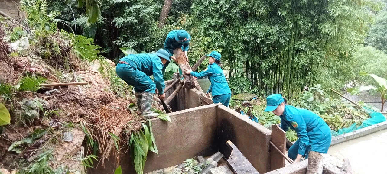 Lực lượng dân quân giúp dân khắc phục hậu quả thiên tai.