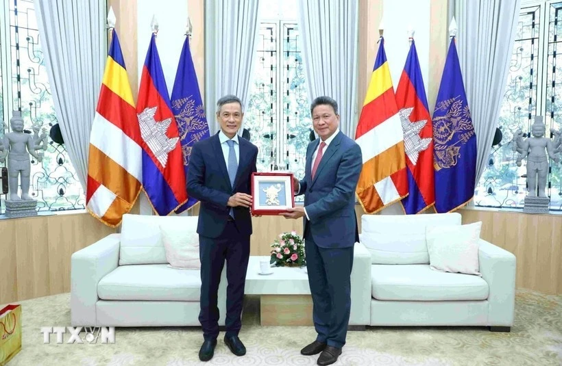 Đại sứ Việt Nam tại Campuchia Nguyễn Minh Vũ (bên trái) trao tặng phẩm lưu niệm cho Phó Thủ tướng kiêm Phó Chủ tịch thứ nhất CDC Sun Chanthol.