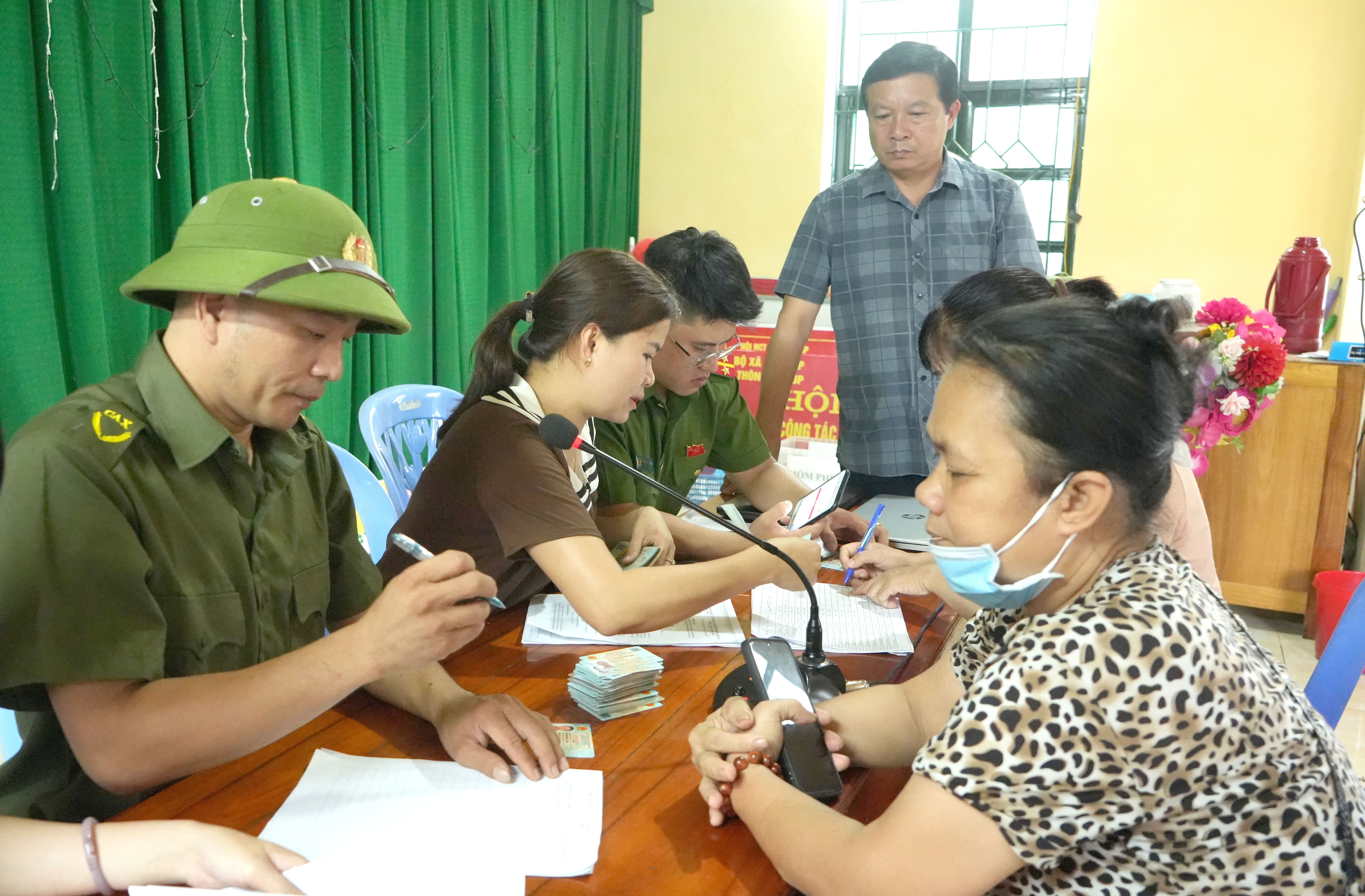 Ông Phạm Huy Mai - Trưởng Phòng Văn hóa - Xã hội xã Trấn Yên (áo kẻ) chứng kiến việc trao quà cho người dân. anh2-2653.jpg