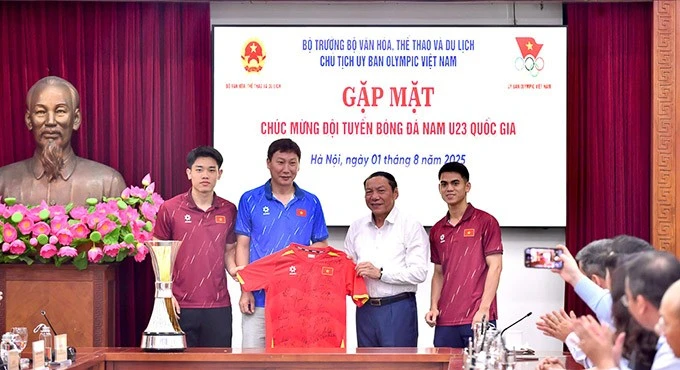 HLV Kim Sang Sik và các cầu thủ trao tặng Bộ trưởng Nguyễn Văn Hùng áo thi đấu có chữ ký của toàn đội.