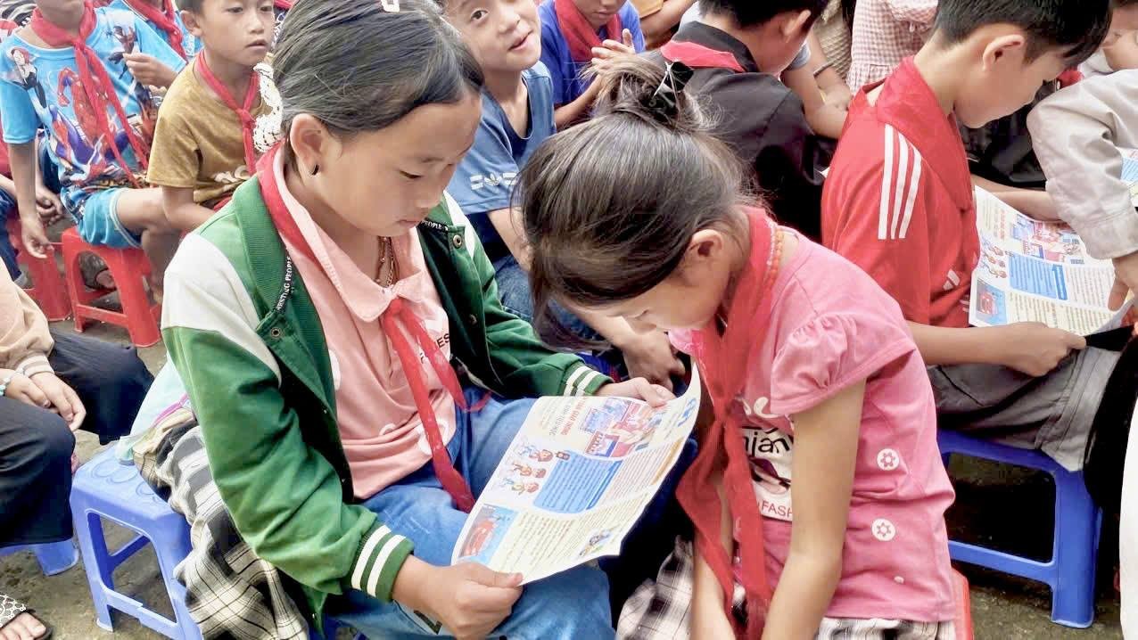 Học sinh chăm chú nghiên cứu thông tin trên tờ rơi tuyên truyền. toroi4.jpg
