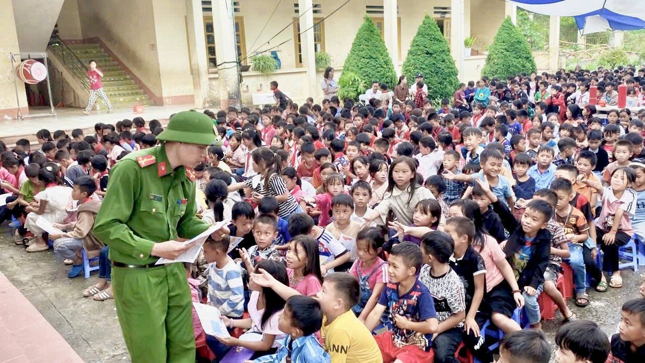Công an xã phát tờ rơi tuyên truyền pháp luật cho học sinh. toroi3.jpg